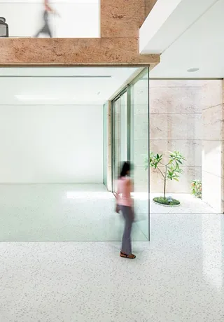 Woman Passing through lobby with a sustainable floor made of recycled plastic  