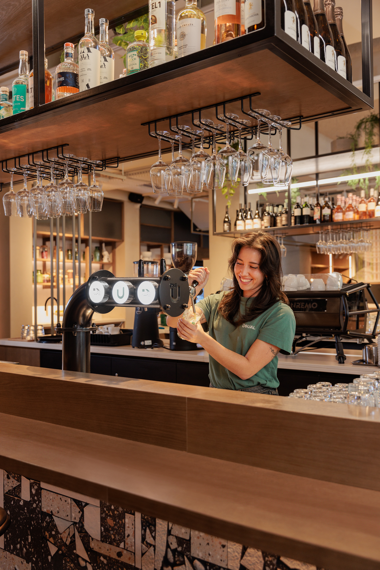 Host tapping a local beer in The U Bar